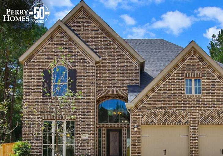 front exterior of dark brown brick two-story house with attached two car garage and glass front door 